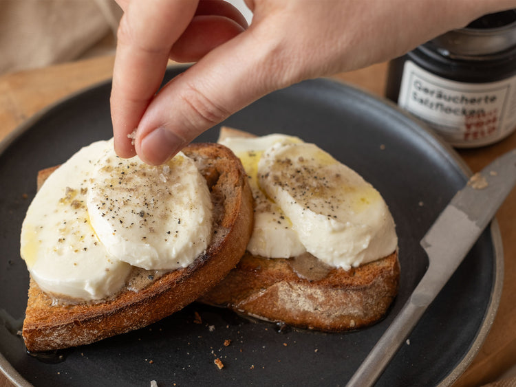 Geräucherte Salzflocken auf geröstetem Brot mit Knoblauchbutter und Mozarellascheiben
