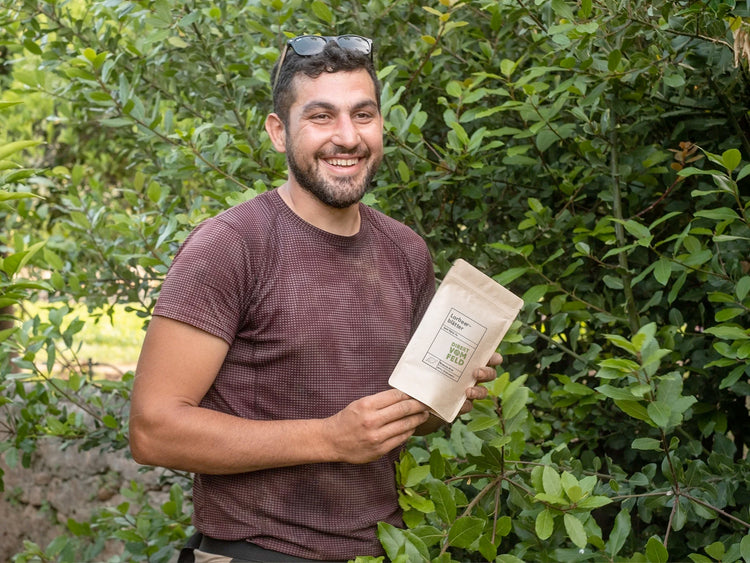 Kräuterbauer Ilias neben dem Lorbeerstrauch