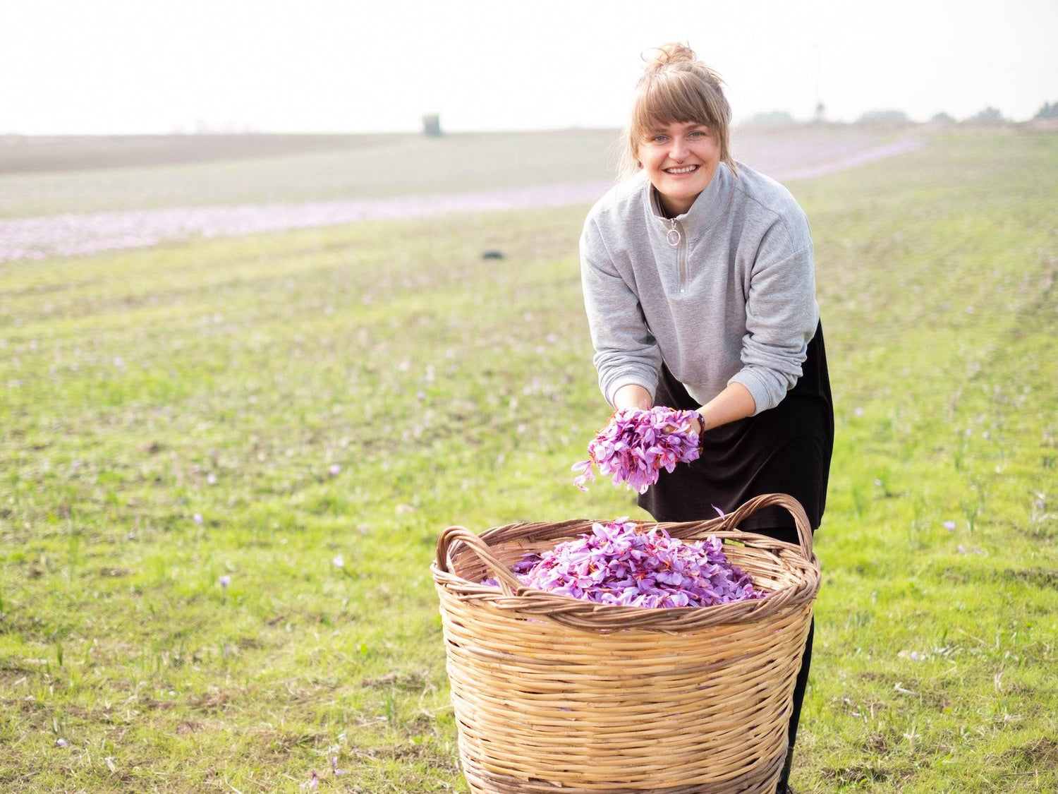 Theresa auf dem Safrangelb mit Safranblüten in den Händen - Direkt vom Feld