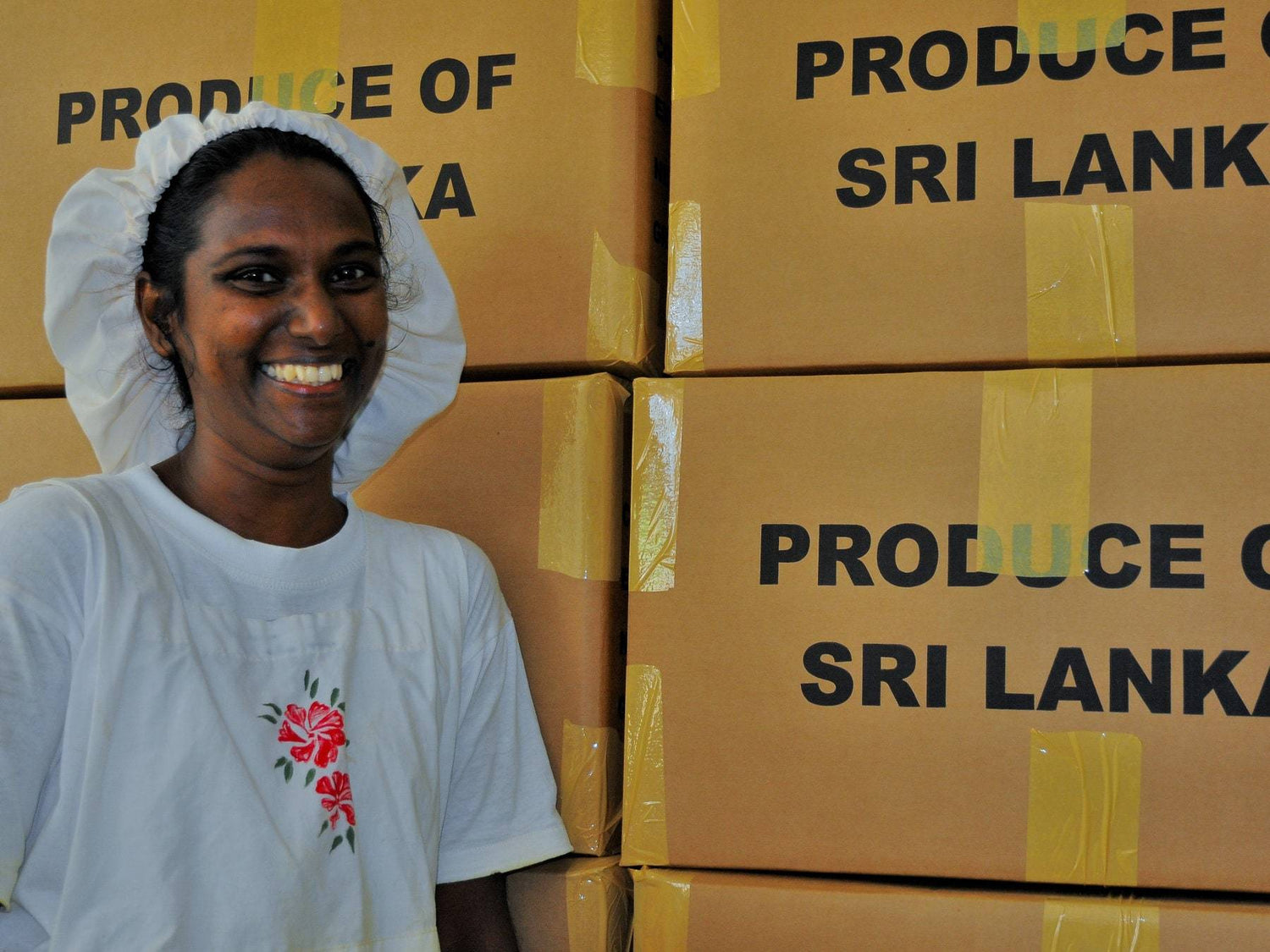 Mitarbeiterin der Kooperative Podie mit Kisten Bio Ceylon-Zimt - Direkt vom Feld